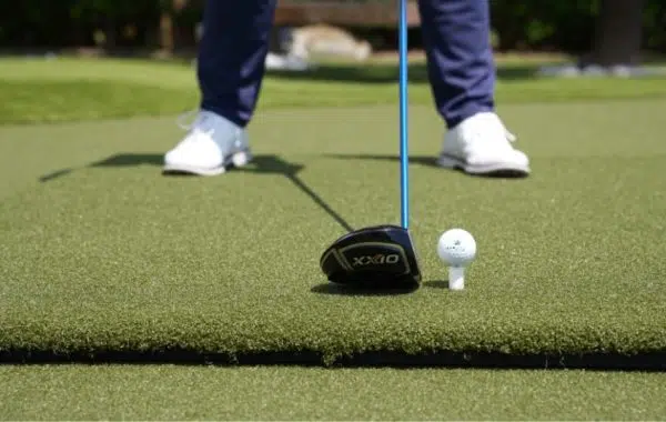 Golfer teeing off on SYNLawn golf mat