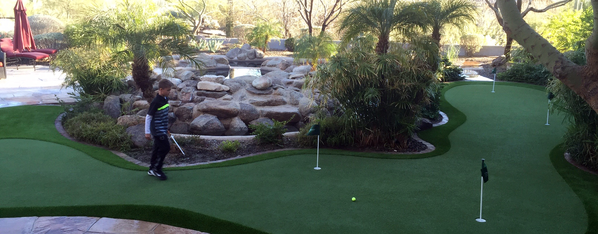 kid on artificial putting green